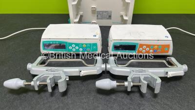 2 x B.Braun Infusomat Space Infusion Pumps (Both Power Up) with 2 x Power Supplies, 2 x B.Braun Space Stations (1 x Damaged / Missing Casing - See Photos) and 2 x Pole Clamps - 2