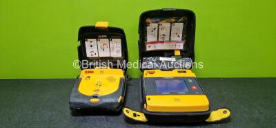 Job Lot Including 1 x Physio Control Lifepak 1000 Defibrillator *Mfd 2014* in Case (Powers Up with Stock Battery - Stock Battery Not Included) with 1 x Li/MnO2 Battery *Flat* and 1 x Physio Control Lifepak CR Plus Defibrillator *Mfd 2018* in Case (Powers 