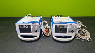 2 x Zoll R Series Plus Defibrillators / Monitors (Both Power Up) Including ECG and Printer Options with 2 x 3 Lead ECG Leads (Both Damaged Casings - See Photos), 2 x Paddle Leads, 2 x Power Cords and 2 x Lithium Ion Rechargeable Batteries *SN AF13B027395 - 2