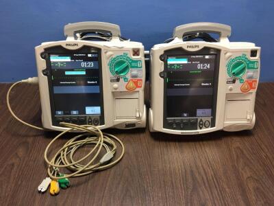 2 x Philips Heartstart MRx Defibrillators Including Pacer, ECG and Printer Options with 2 x Paddle Leads and 1 x ECG Leads (Both Power Up with 2 x Bat