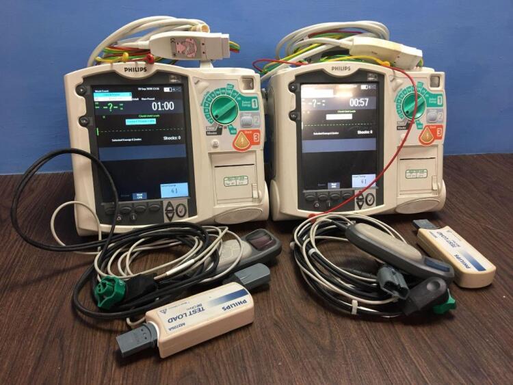 2 x Philips Heartstart MRx Defibrillators Including Pacer, ECG and Printer Options with 2 x Paddle Leads, 2 x ECG Leads,2 x 50 Ohm Test Loads, 2 x Lae