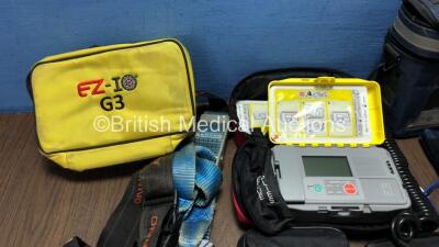 Mixed Lot Including 1 x Access ALS Automated External Defibrillator (Powers Up with Loose Battery Clip-See Photo) 1 x Max NIBP CAS 740 Vital Signs Monitor (No Power) 1 x EZ IO G3 Carry Bag, 8 x Merlin Medical BP Meters and 2 x Ferno Belts - 2