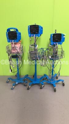 2 x GE Carescape V100 Vital Signs Monitors on Stands with 2 x SPO2 Finger Sensors and 2 x BP Hoses and 1 x GE ProCare Auscultatory 400 Vital Signs Monitor on Stand with SPO2 Finger Sensor and BP Hose (All Power Up)