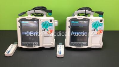 2 x Philips MRx Defibrillators Including Pacer, ECG and Printer Options with 2 x Philips M3538A Batteries, 2 x Philips M3539A Modules, 2 x Paddle Leads and 2 x Philips M3725A Test Loads (Both Power Up)