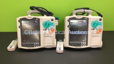 2 x Philips MRx Defibrillators Including Pacer, ECG and Printer Options with 2 x Philips M3538A Batteries, 2 x Philips M3539A Modules, 2 x Paddle Leads and 2 x Philips M3725A Test Loads (Both Power Up)