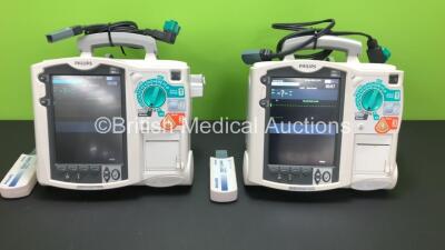 2 x Philips MRx Defibrillators Including Pacer, ECG and Printer Options with 2 x Philips M3538A Batteries, 2 x Philips M3539A Modules, 2 x Paddle Leads and 2 x Philips M3725A Test Loads (Both Power Up)