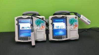 2 x Philips MRx Defibrillators Including ECG and Printer Options with 2 x Philips M3538A Batteries and 2 x Philips M3539A Modules, 2 x Paddle Leads and 2 x Philips M3725A Test Loads (Both Power Up)