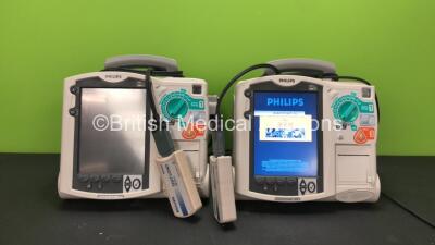 2 x Philips MRx Defibrillators Including ECG and Printer Options with 2 x Philips M3538A Batteries and 2 x Philips M3539A Modules, 2 x Paddle Leads and 2 x Philips M3725A Test Loads (Both Power Up)