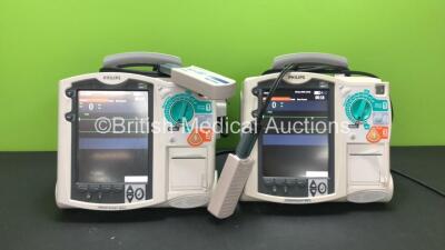 2 x Philips MRx Defibrillators Including ECG and Printer Options with 2 x Philips M3538A Batteries and 2 x Philips M3539A Modules, 2 x Paddle Leads and 2 x Philips M3725A Test Loads (Both Power Up)