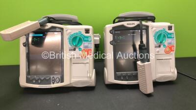 2 x Philips MRx Defibrillators Including Pacer, ECG and Printer Options with 2 x Philips M3538A Batteries and 2 x Philips M3539A Modules, 2 x Paddle Leads and 2 x Philips M3725A Test Loads (Both Power Up)