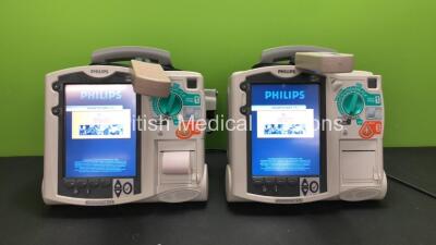 2 x Philips MRx Defibrillators Including Pacer, ECG and Printer Options with 2 x Philips M3538A Batteries, 2 x Philips M3539A Modules, 2 x Paddle Leads and 2 x Philips M3725A Test Loads (Both Power Up)