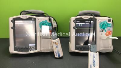 2 x Philips MRx Defibrillators Including ECG and Printer Options with 2 x Philips M3538A Batteries, 2 x Philips M3539A Modules, 2 x Paddle Leads and 2 x Philips M3725A Test Loads (Both Power Up)