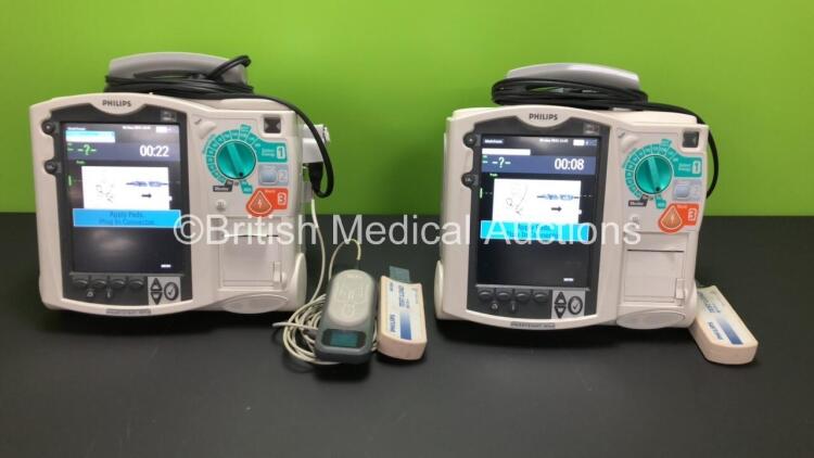 2 x Philips Heartstart MRx Defibrillators Including ECG and Printer Options with 2 x Paddle Leads and 2 x Philips M3725A Test Loads, 1 x QCPR Meter, 2 x M3539A Modules and 2 x Philips M3538A Batteries *Mfd 2011 - 2011* (Both Power Up)