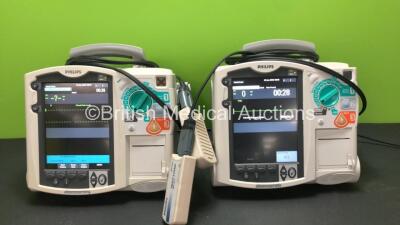 2 x Philips MRx Defibrillators Including Pacer, ECG and Printer Options with 2 x Philips M3538A Batteries, 2 x Philips M3539A Modules, 2 x Paddle Leads and 2 x Philips M3725A Test Loads (Both Power Up)