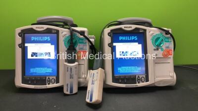 2 x Philips MRx Defibrillators Including ECG and Printer Options with 2 x Philips M3538A Batteries, 2 x Philips M3539A Modules, 2 x Paddle Leads and 2 x Philips M3725A Test Loads (Both Power Up)