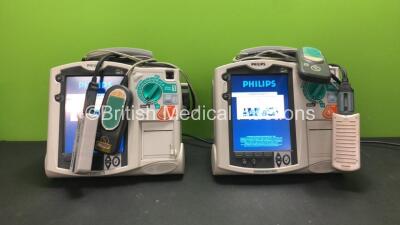 2 x Philips MRx Defibrillators Including ECG and Printer Options with 2 x Philips M3538A Batteries, 2 x Philips M3539A Modules, 2 x Paddle Leads, 2 x Philips M3725A Test Loads and 2 x Laerdal QCPR Modules (Both Power Up)