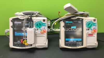 2 x Philips MRx Defibrillators Including Pacer, ECG and Printer Options with 2 x Philips M3538A Batteries, 2 x Philips M3539A Modules, 2 x Paddle Leads, 2 x 3 Lead ECG Leads and 2 x Philips M3725A Test Loads (Both Power Up) *SN US00214826 - US00214827*