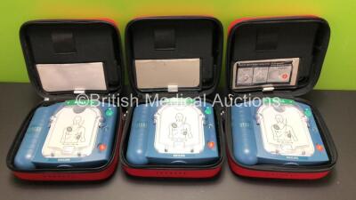 3 x Philips Heartstart HS1 Defibrillators with 3 x Carry Cases and 3 x Batteries (All Power Up) *A09F 03140 - A09F 03138 - A09F 03124*