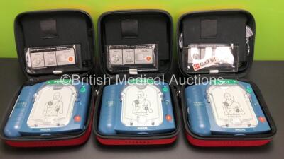 3 x Philips Heartstart HS1 Defibrillators with 3 x Carry Cases and 3 x Batteries (All Power Up) *A09F 02999 - A09F 03029 - A15F 05738*