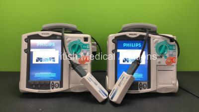 2 x Philips MRx Defibrillators Including ECG and Printer Options with 2 x Philips M3538A Batteries and 2 x Philips M3539A Modules, 2 x Paddle Leads and 2 x Philips M3725A Test Loads (Both Power Up)