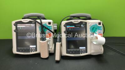 2 x Philips MRx Defibrillators Including Pacer, ECG and Printer Options with 2 x Philips M3538A Batteries, 2 x Philips M3539A Modules, 2 x Paddle Leads and 2 x Philips M3725A Test Loads (Both Power Up)