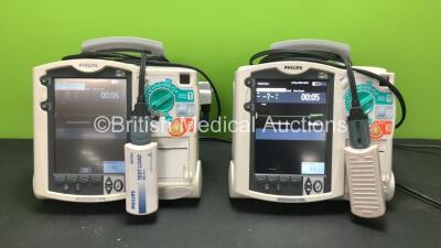 2 x Philips MRx Defibrillators Including Pacer, ECG and Printer Options with 2 x Philips M3538A Batteries, 2 x Philips M3539A Modules, 2 x Paddle Leads and 2 x Philips M3725A Test Loads (Both Power Up)