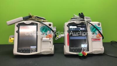 2 x Philips MRx Defibrillators Including ECG and Printer Options with 2 x Philips M3538A Batteries, 2 x Philips M3539A Modules, 2 x Paddle Leads, 2 x 3 Lead ECG Leads and 2 x Philips M3725A Test Loads (Both Power Up 1 with Damaged Printer Cover-See Photo)