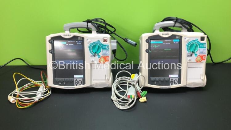 2 x Philips Heartstart MRx Defibrillators Including 1 x Pacer, 2 x ECG and Printer Option with 2 x Philips M3539A Batteries, 2 x Philips M3538 Module, 2 x ECG Leads and 2 x Paddle Lead (Both Power Up) *SN US00534795 - US00214786*