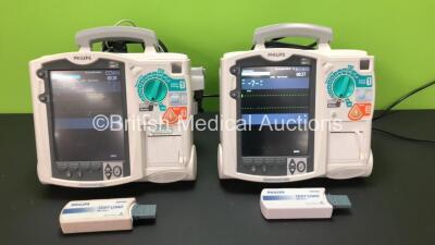 2 x Philips Heartstart MRx Defibrillators Including Pacer, ECG and Printer Option with 2 x Philips M3539A Batteries, 2 x Philips M3538 Module and 2 x Paddle Leads with Test Loads *Mfd 2015-2007* (Both Power Up) *SN US00589807 - US00321982*