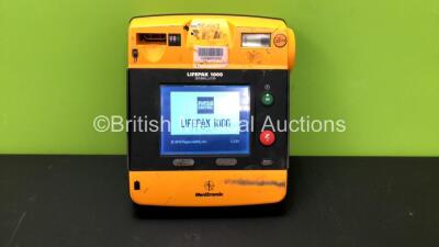 Medtronics Lifepak 1000 Defibrillator with 1 x Physio Control Ref 11141000156 Battery (Powers Up with Damaged Casing-See Photo)