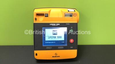 Medtronics Lifepak 1000 Defibrillator with 1 x Physio Control Ref 11141000156 Battery (Powers Up with Damaged Casing-See Photo)