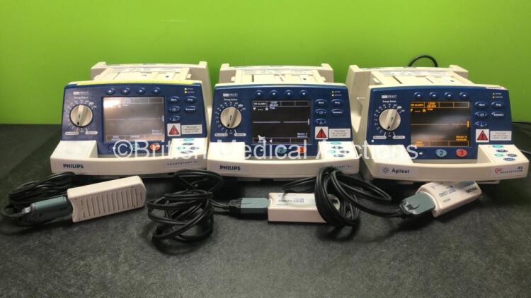 2 x Philips Heartstart XL Smart Biphasic Defibrillators Including Pacer, ECG and Printer Options and 1 x Agilent Heartstream Smart Biphasic Defibrillator Including Pacer ECG and Printer Options with 3 x Paddle Leads and 3 x Philips M3725A Test Loads (All