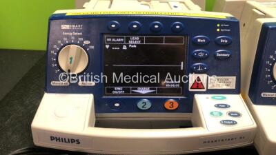 2 x Philips Heartstart XL Smart Biphasic Defibrillators Including Pacer, ECG and Printer Options and 1 x Agilent Heartstream Smart Biphasic Defibrillator Including Pacer ECG and Printer Options with 3 x Paddle Leads and 3 x Philips M3725A Test Loads (All - 2