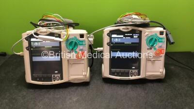 2 x Philips MRx Defibrillators Including ECG and Printer Options with 2 x Philips M3539A Power Adapters 2 x Paddle Lead, and 2 x 3 Lead ECG Leads (Both Power Up) *US00546541, US00546547*