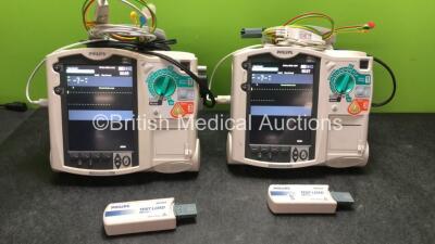 2 x Philips MRx Defibrillators Including Pacer, ECG and Printer Options with 2 x Philips M3539A Power Adapters, 2 x Philips M3538A Batteries, 2 x Paddle Lead, and 2 x 3 Lead ECG Leads (Both Power Up) *US00554890, US00546521*