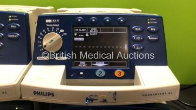 4 x Philips Heartstart XL Smart Biphasic Defibrillators with ECG and Printer Options, 4 x Test Loads, 4 x Paddle Leads, 4 x 3 Lead ECG Leads and 4 x Batteries (All Power Up) *US00122134 / US00448295 / US00116839 / US00588708* - 2
