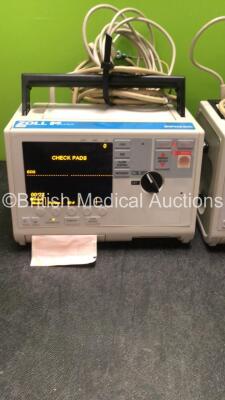 2 x Zoll M Series Biphasic Defibrillators Including ECG and Printer Options with 2 x Batteries, 2 x Patch Cables and 2 x 3 Lead ECG Leads (Both Power Up) *SN TZ7I94297, T06K85376* - 5