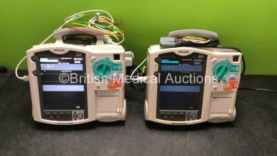 2 x Philips MRx Defibrillators Including ECG and Printer Options with 2 x Philips M3539A Power Adapters 2 x Paddle Lead, and 2 x 3 Lead ECG Leads (Both Power Up) *US00565620, US003151575*