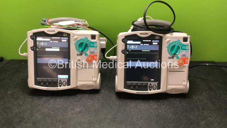 2 x Philips MRx Defibrillators Including ECG and Printer Options with 2 x Philips M3539A Power Adapters 2 x Paddle Lead, and 2 x 3 Lead ECG Leads (Both Power Up) *US00546452, US00546540*