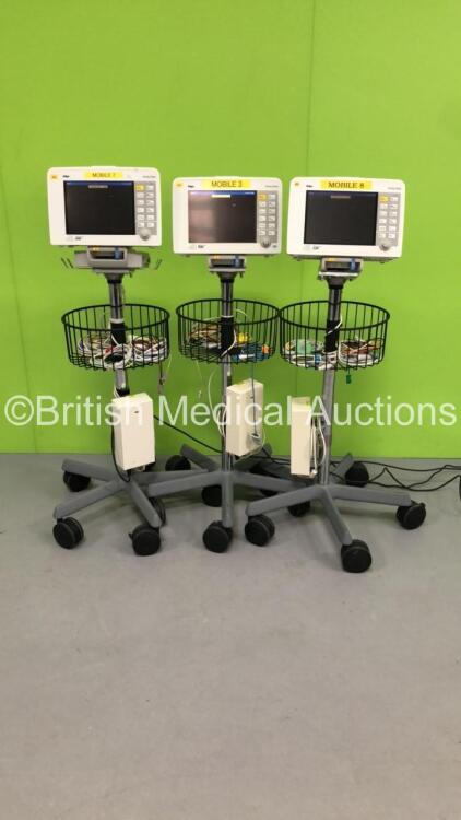 3 x Drager Infinity Delta Patient Monitors with HemoMed1, NIBP, Aux/Hemo3 and MultiMed Options, 2 x 5 Lead ECG Leads, 2 x 3 Lead ECG Leads, 2 x SPO2 Finger Sensors, 3 x Docking Stations and 3 x Power Supplies on Stands (All Power Up, 2 with Damaged Casing