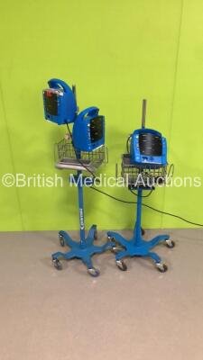 3 x GE ProCare Patient Monitors on 2 x Stands (2 x Power Up,1 x No Power-1 x Missing Mounting Bracket)