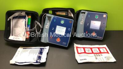 1 x Philips Heartstart FR2+ and 1 x Laerdal FR2 Defibrillators in Carry Cases with 2 x Batteries *Instal Dates 04-2026 - 07-2024 * and 2 x Electrode Packs (Both Power Up, 1 x Passes Self Test, 1 x Fails)