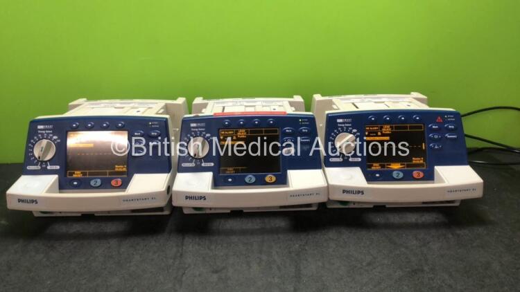 3 x Philips Heartstart XL Smart Biphasic Defibrillator Including ECG and Printer Options (All Power Up, 1 with Damaged Screen and Missing Button and 1 with Damaged Handle-See Photos) *SN US00117317, US00117304, US00117311*