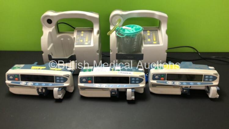 Mixed Lot Including 2 x Oxylitre Suction Units with 1 x Serres Cup and Lid (Both Power Up) and 3 x Cardinal Health Alaris GH Syringe Pumps (All Draw Power with Blank Screens)