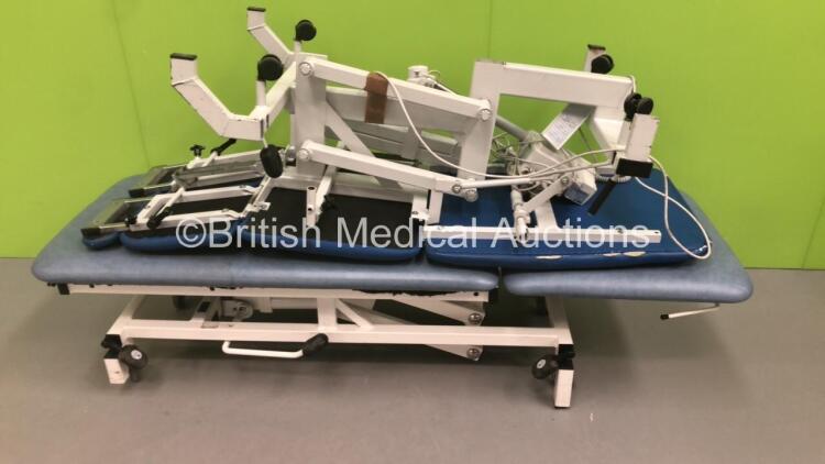 1 x Plinth 2000 3-Way Electric Patient Examination Couch with Controller and 1 x Huntleigh Akron Hydraulic Patient Couch (1 x Powers Up,1 x Hydraulics Not Working-Damage to Cushions-See Photos)