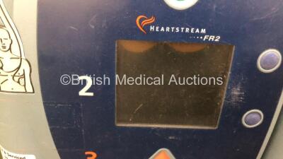 Job Lot Including 1 x Laerdal Heartstart FR2 Defibrillator (Powers Up with Faulty Screen) and 1 x Agilent HeartStream FR2 Defibrillator (No Power) with 2 x Batteries Install By - 10/2018 and 9/2026 - 3