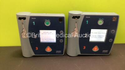 2 x Philips Heartstart FR2+ Defibrillators with 2 x Batteries Install By - 10/2023 and 2/2022 (Both Power Up in French Display, 2 Low Batteries Included) - 2