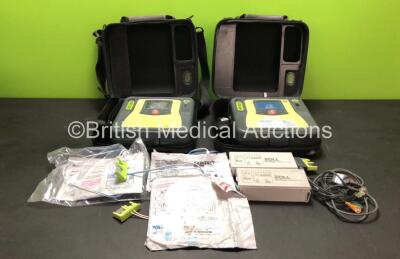 2 x Zoll AED Pro Defibrillators with 3 x Batteries, 1 x ECG Lead and 4 x Electrode Packs (1 x In Date) in 2 x Carry Cases (Both Power Up with Some Marks to Screen - See Photo)