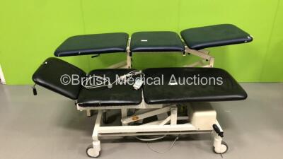 1 x Akron Hydraulic 3 Way Patient Examination Couch (Hydraulics Tested Working - Rip in Cushion) and 1 x Huntleigh Akron Electric 3 Way Patient Examination Couch with Controller (Powers Up)