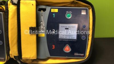 2 x Laerdal Heartstart FR2 Defibrillators in Carry Bags with 3 x Philips M3863A Batteries and 5 x Electrode Packs *3 x Expired* (Both Power Up and Pass Self Tests) **SN 1002073519 / 1002073515** - 2